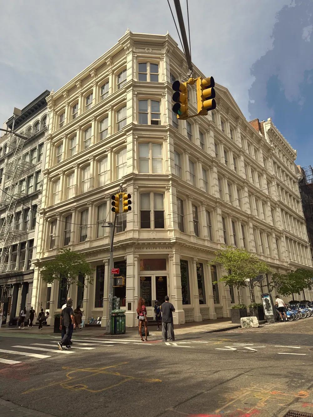 An ornate cast-iron commercial building at a street corner in SoHo.